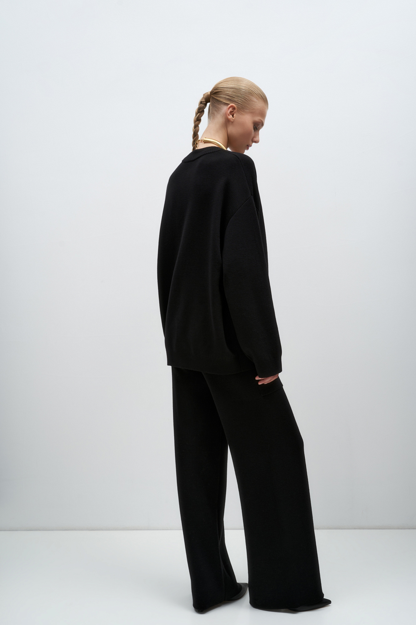 Трикотажные брюки в основе из шерсти мериноса. Модель свободного силуэта со стрелками, боковыми карманами и эластичным поясом. Дополнить образ можно комплектными жилетом и бомбером.