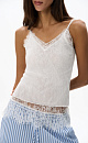 Трикотажный топ из тонкого хлопка. Модель в рубчик на тонких бретельках и глубоким вырезом декольте. Изделие декорировано кружевом.