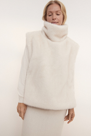 молочный Жилет из экомеха с воротником-стойкой и карманом-кенгуру. Модель фиксируется по бокам на кнопки. Изделие выполнено на подкладке.