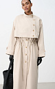 Однобортный тренч с асимметричной отлетной кокеткой. Модель свободного кроя, с воротником-стойкой, патами на манжетах и боковыми карманами. Акцент на талию с помощью регулируемой кулиски. Изделие без подкладки. Застежка на пуговицы.