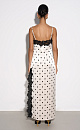 Атласное платье-комбинация длины макси в горох. Модель приталенного силуэта на тонких бретельках и высоким разрезом сбоку. Изделие декорировано кружевом.