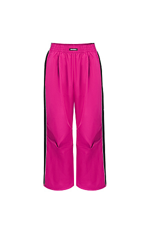 фуксия Детские брюки в спортивном стиле с карманами по бокам, белым кантом и широким лампасом. Пояс на эластичной ленте с брендированным ярлыком, манжеты на регулируемой кулиске. Дополнить образ можно курткой в том же стиле.<br />
