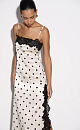 Атласное платье-комбинация длины макси в горох. Модель приталенного силуэта на тонких бретельках и высоким разрезом сбоку. Изделие декорировано кружевом.