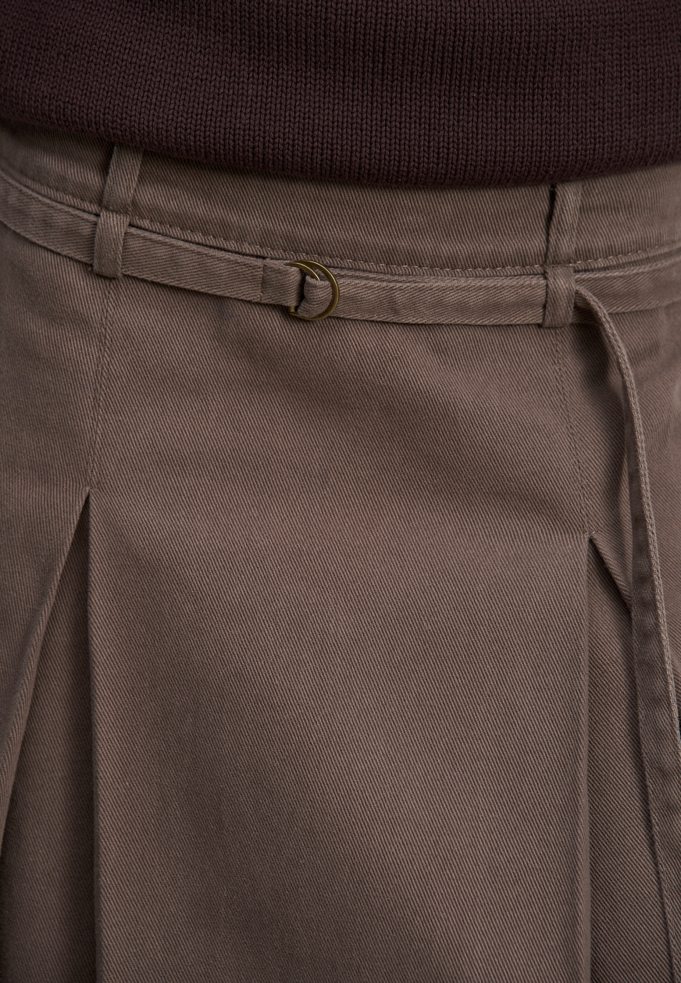 Джинсовая юбка из 100% хлопка длины миди. Модель прямого кроя, с крупными встречными складками, двойным поясом со шлевками для ремня, тонким ремешком и застежкой на молнию сбоку.