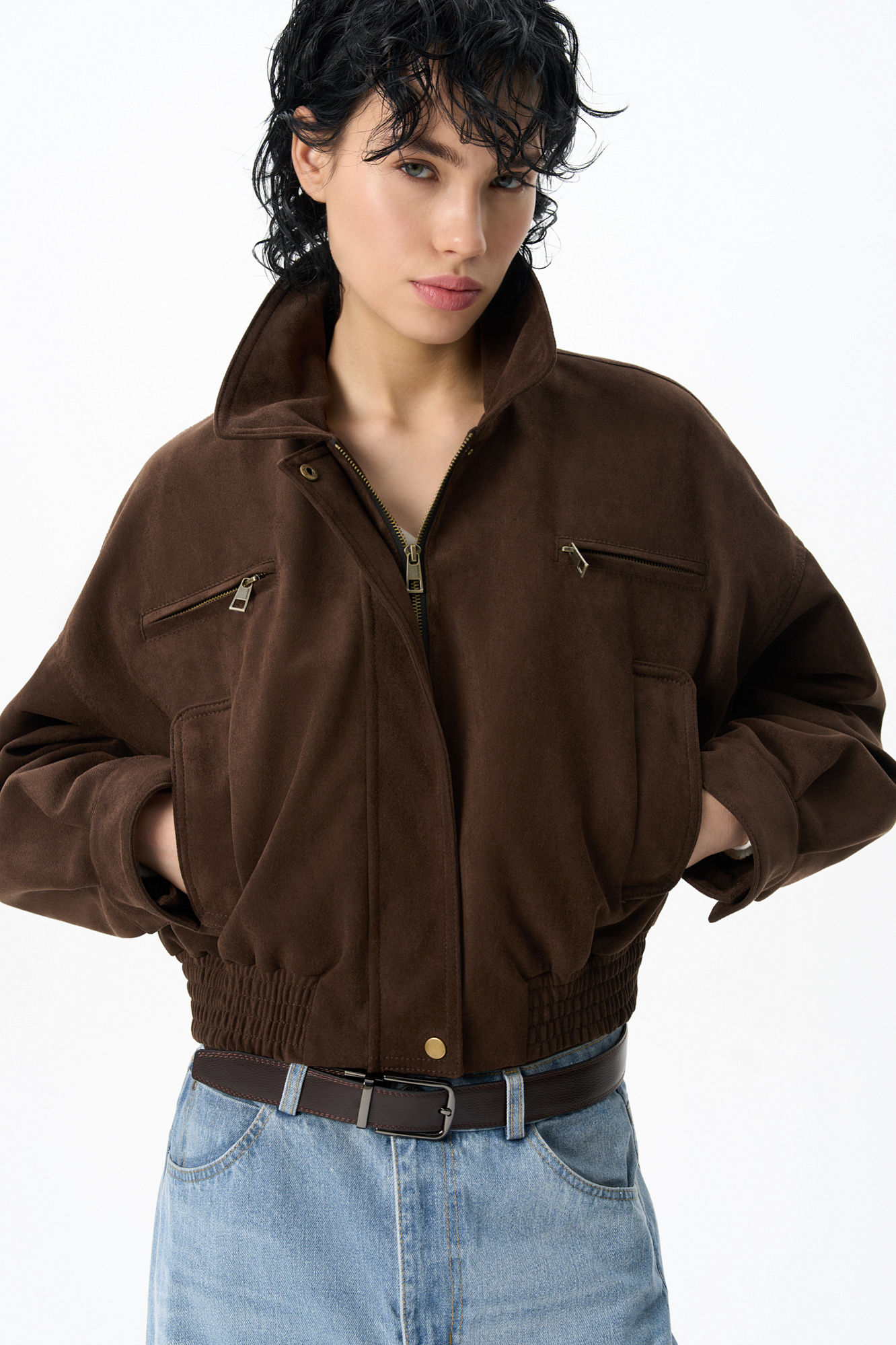 Бомбер из ткани с имитацией внешнего вида и свойств натуральной замши. Модель свободного силуэта со спущенной линией плеча, с отложным воротником, двумя нагрудными карманами на молнии и двумя боковыми карманами. Низ изделия выполнен на резинке. Застежка на молнию под планкой. На подкладке.