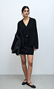 Трикотажная юбка длины мини из шерсти мериноса. Модель с боковой планкой на кнопках, небольшим вырезом сбоку, накладными карманами сзади и широким эластичным поясом на резинке. Дополнить образ можно жилетом, жакетом или бомбером.