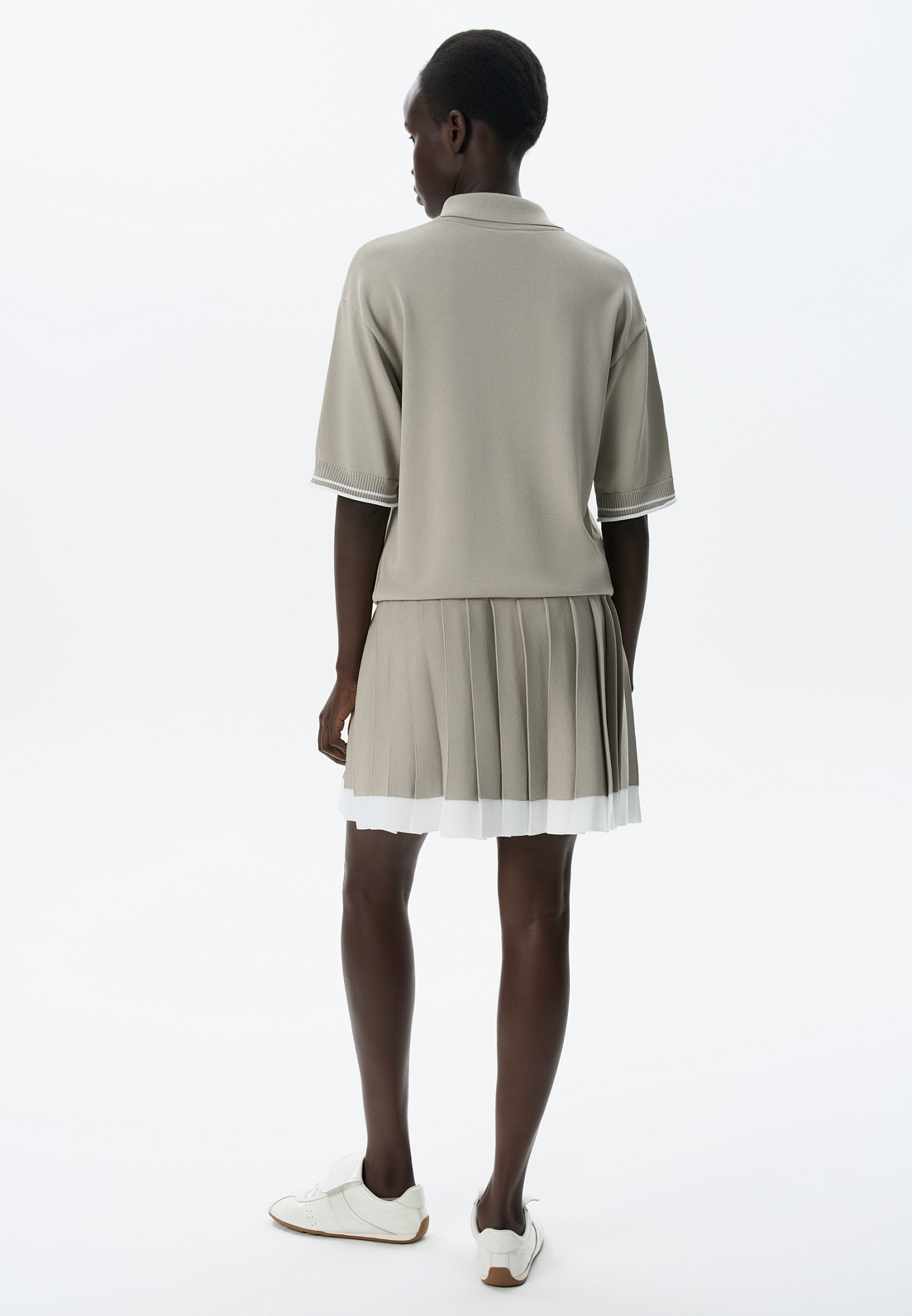 Трикотажная юбка плиссе длины мини из вискозы. Модель с широким эластичным поясом в рубчик. Пояс и нижняя часть юбки выполнены из пряжи контрастного цвета.