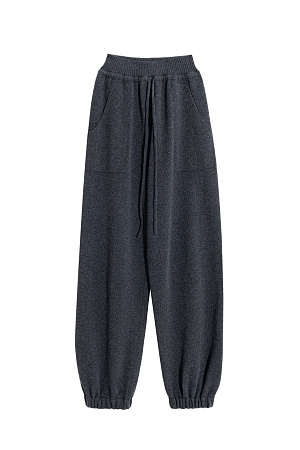 графит Трикотажные брюки-бананы из кашемира и шерсти. Модель свободного силуэта, с эластичным поясом в рубчик, дополненным кулиской, и двумя большими карманами. Манжеты выполнены на резинках.