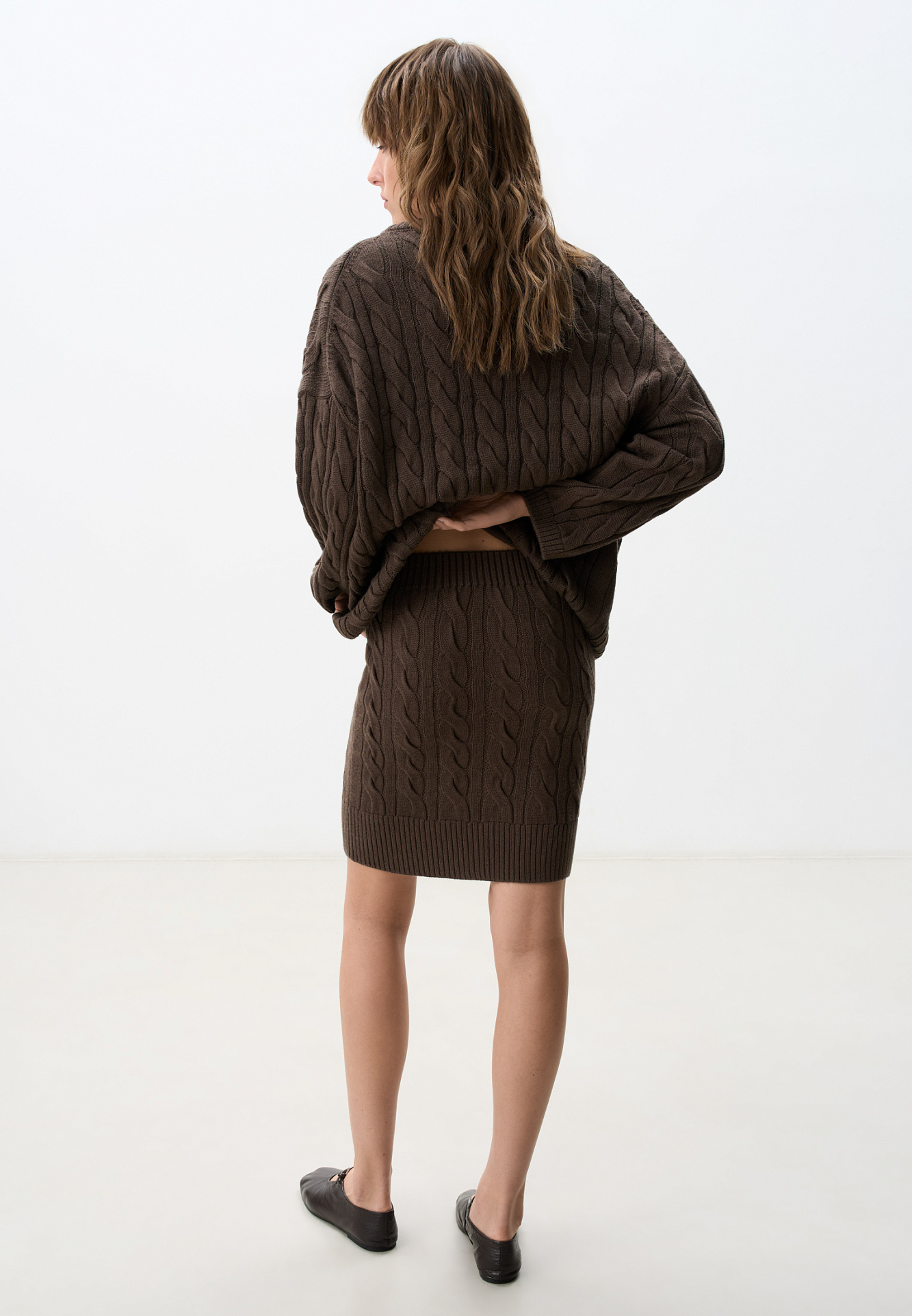 Трикотажная юбка длины мини с объемными косами из мягкой шерсти. Широкий эластичный пояс на кулиске. Дополнить образ можно джемпером в том же стиле.