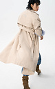 Двубортный длинный тренч прямого кроя. Модель с отложным воротником, декорированным металлической перемычкой, отлетной кокеткой, патами с пуговицами на манжетах, карманами и шлевками на талии для пояса. 