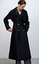Двубортный длинный тренч прямого кроя. Модель с отложным воротником, декорированным металлической перемычкой, отлетной кокеткой, патами с пуговицами на манжетах, карманами и шлевками на талии для пояса.