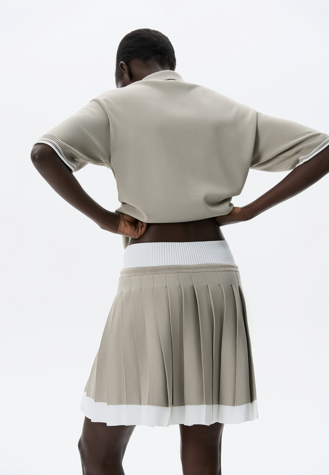 Трикотажная юбка плиссе длины мини из вискозы. Модель с широким эластичным поясом в рубчик. Пояс и нижняя часть юбки выполнены из пряжи контрастного цвета.