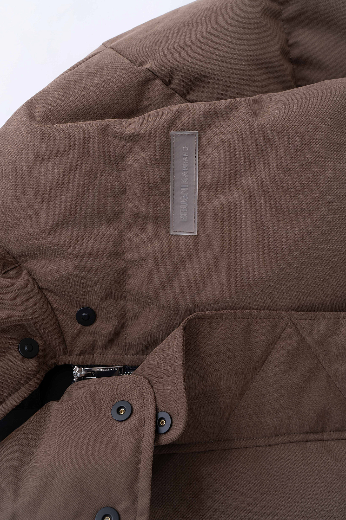 Утепленный пуховик с воротником-стойкой и капюшоном на молнии. Модель свободного силуэта с боковыми карманами, спущенным плечом и брендированным ярлыком на груди. Застежка на потайную молнию и кнопки. Наполнитель натуральный пух 90% перо 10%.