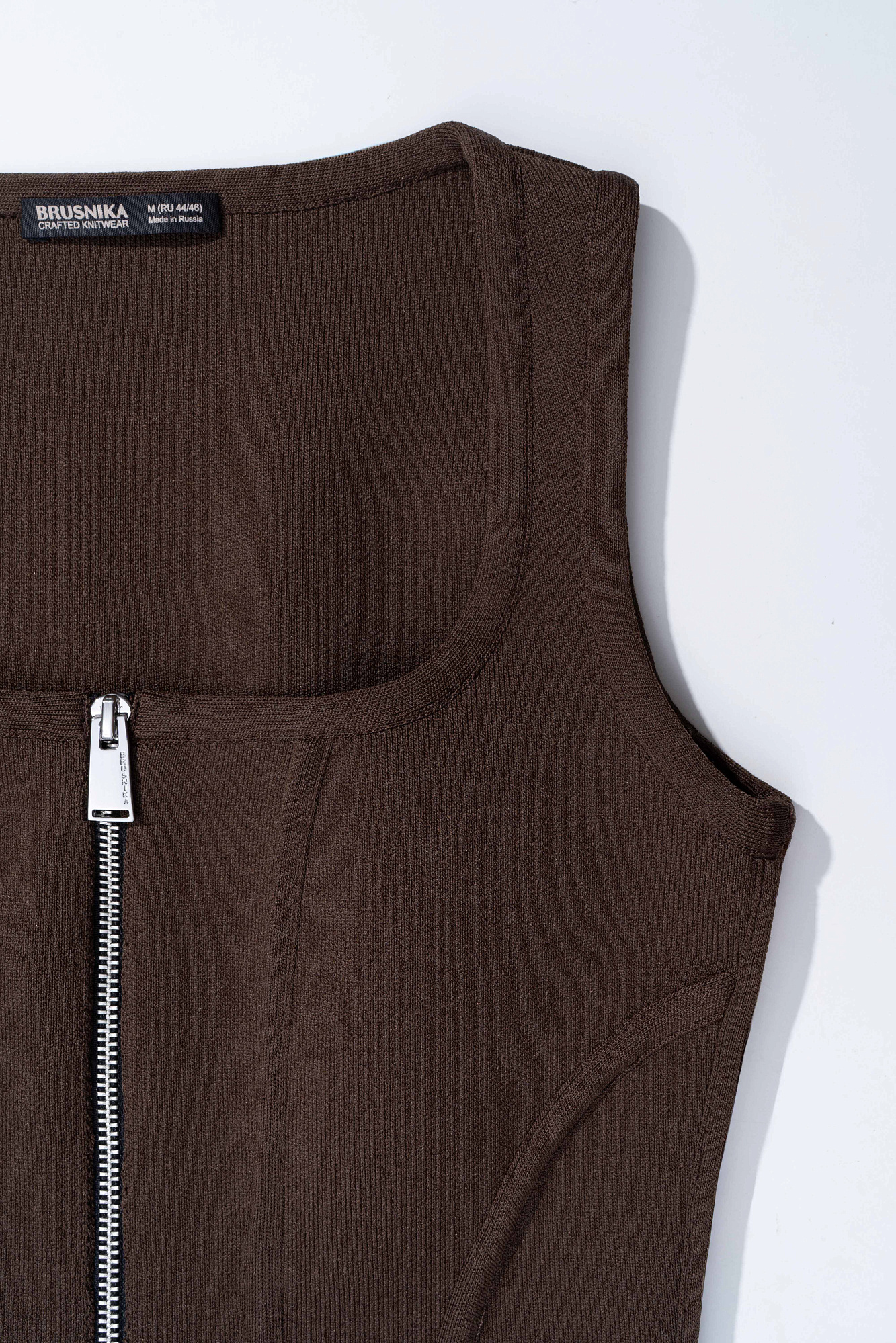 Трикотажный корсет из вискозы, выполненый плотной вязкой. Модель по фигуре, с вертикальными объемными вытачками, без рукавов, с квадратным вырезом горловины. Изделие имеет застежку на молнию по всей длине. Без подкладки.