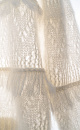 Ажурный джемпер с вывязанным узором и бахромой. Модель свободного силуэта со спущенной линией плеч и круглым вырезом горловины. Края изделия выполнены в рубчик. 