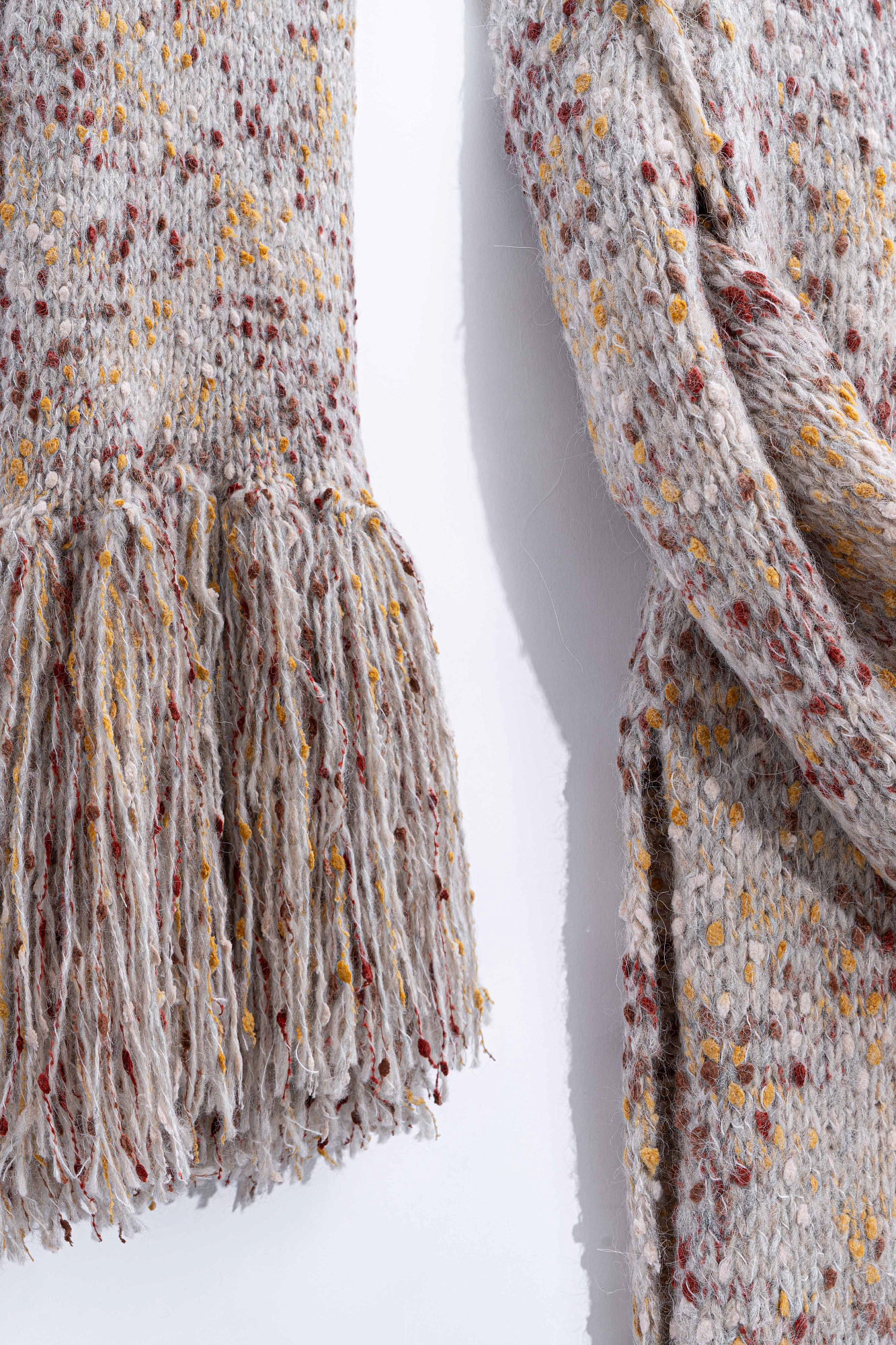 Трикотажный шарф из буклированной пряжи с длинной бахромой.