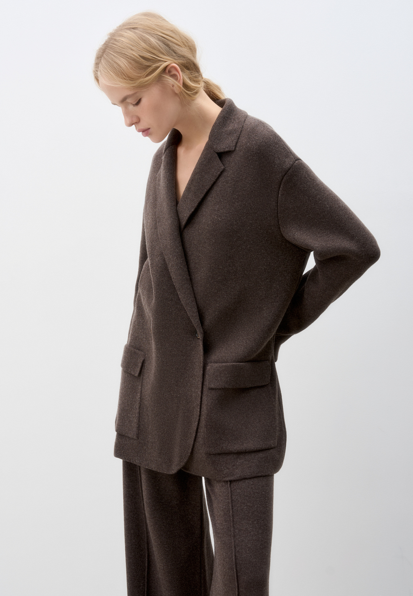 Трикотажный двубортный жакет из смесовой шерсти с добавлением кашемира. Модель прямого кроя, с прямоугольными лацканами и накладными карманами с клапанами спереди. Изделие без подкладки.