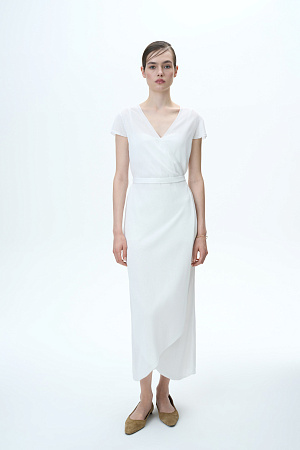 белый Лёгкое трикотажное платье станет прекрасным спутником летних дней. V-образный вырез идеально подходит для объёмных аксессуаров, а асимметричный край юбки добавляет образу элегантности.