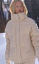 Объемный стеганый пуховик, декорированый комбинированной ажурной вязкой. Модель с воротником-стойкой, боковыми карманами и застежкой на молнию под планкой с кнопками. 