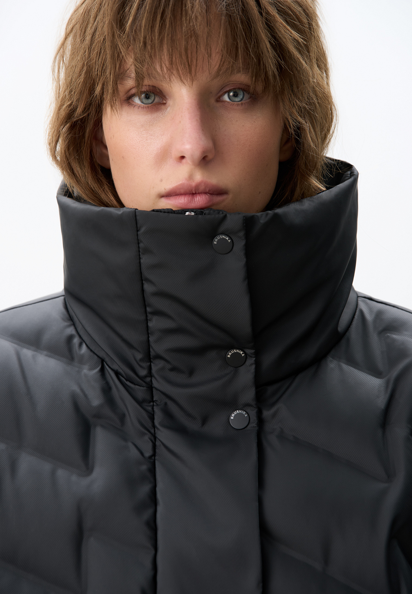 Объемный стеганый жилет на пуху. Модель прямого кроя, с воротником стойкой и боковыми карманами. Застежка на молнию и кнопки под планкой.