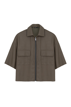 хаки Укороченная рубашка из экокожи. Модель свободного силуэта со спущенной линией плеча, накладными карманами на груди и застежкой на молнию.