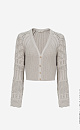 Трикотажный кардиган из хлопка с добавлением эластана. Модель укороченного кроя, с длинными вывязанными рукавами и застежкой на пуговицы.