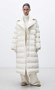Длинный пуховик с брендированным тиснением. Модель свободного силуэта с широким отложным воротником без капюшона. Застежка на пуговицы. Изделие на подкладке.