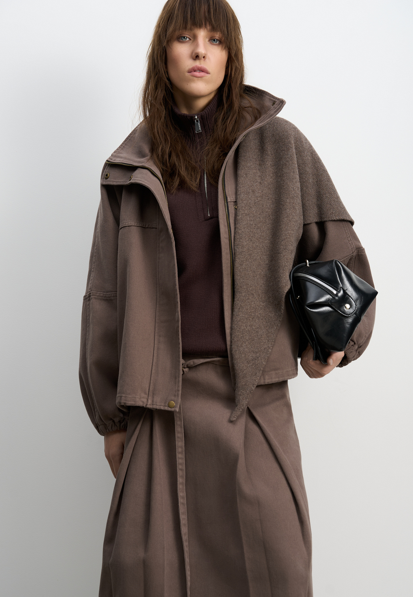 Джинсовая юбка из 100% хлопка длины миди. Модель прямого кроя, с крупными встречными складками, двойным поясом со шлевками для ремня, тонким ремешком и застежкой на молнию сбоку.