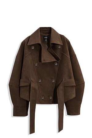 коричневый Двубортный короткий тренч сложной геометрии, выполненный из ткани с имитацией внешнего вида и свойств натуральной замши. Модель с отложным воротником, свободными рукавами со спущенной линией плеч, шлевками на поясе и ремнем.