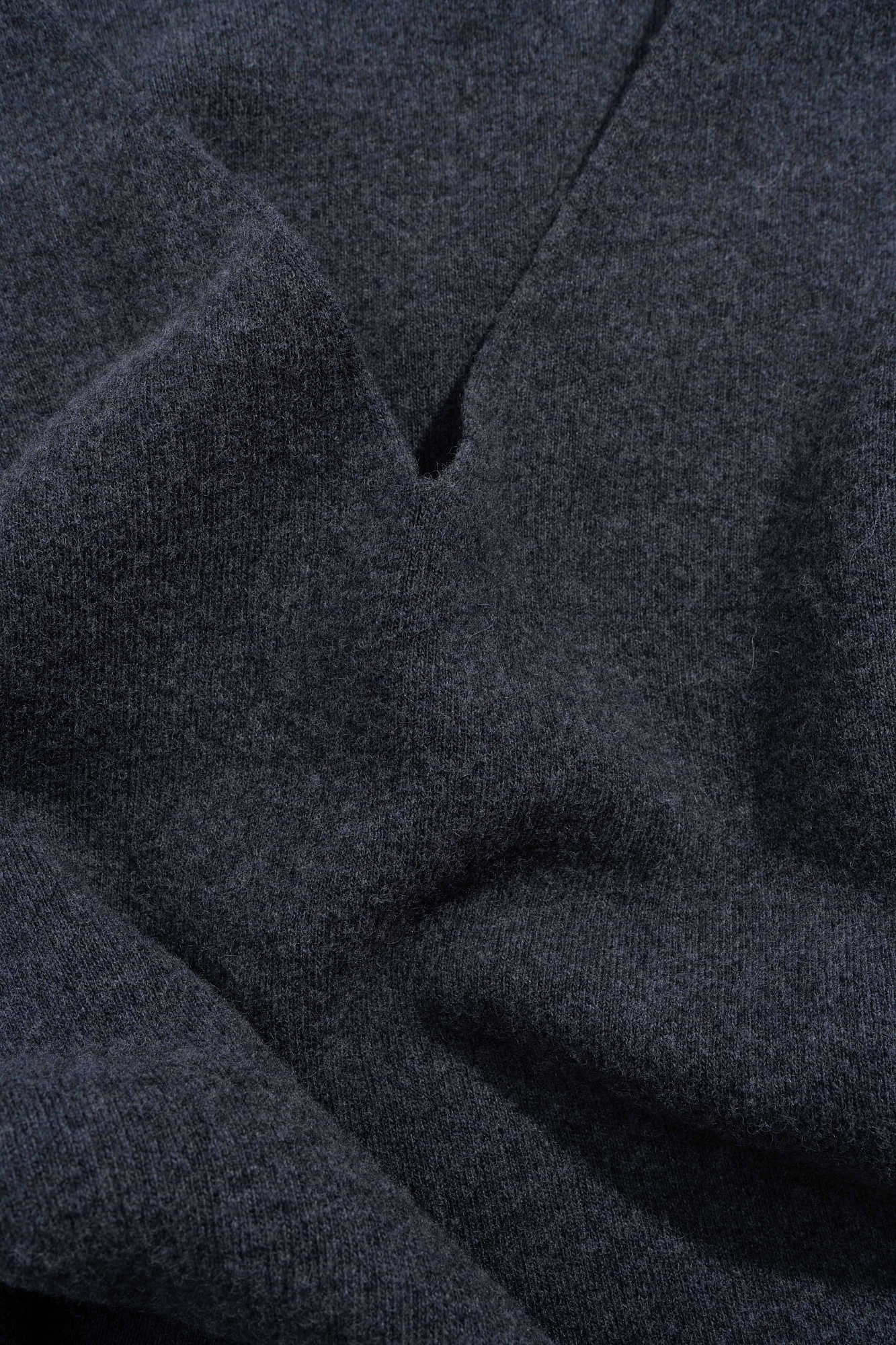 Трикотажный джемпер из шерсти с добавлением кашемира. Модель свободного силуэта со спущенной линией плеч и V-образным вырезом горловины. Манжеты рукавов и низ изделия выполнены в рубчик.