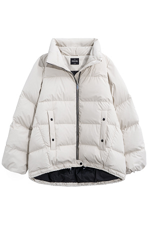 молочный Объемный стеганый пуховик. Модель свободного силуэта с боковыми карманами на кнопках, воротником-стойкой и капюшоном. Низ изделия выполнен на регулируемой кулиске. Застежка на молнию и кнопку.