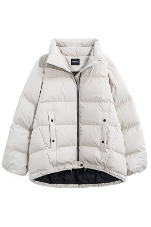молочный Объемный стеганый пуховик. Модель свободного силуэта с боковыми карманами на кнопках, воротником-стойкой и капюшоном. Низ изделия выполнен на регулируемой кулиске. Застежка на молнию и кнопку.