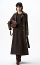 Двубортный длинный тренч прямого кроя. Модель с отложным воротником, декорированным металлической перемычкой, отлетной кокеткой, патами с пуговицами на манжетах, карманами и шлевками на талии для пояса.