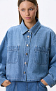 Укороченная джинсовая рубашка из 100% хлопка. Модель свободного силуэта, с отложным воротником, длинными рукавами и нагрудными карманами. Застежка на пуговицы.