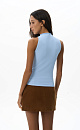 Трикотажный топ, выполненный из вискозы. Модель без руков с американской проймой и невысоким воротником. Изделие декорировано металлической перемычкой.