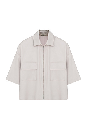 молочный Укороченная рубашка из экокожи. Модель свободного силуэта со спущенной линией плеча, накладными карманами на груди и застежкой на молнию.