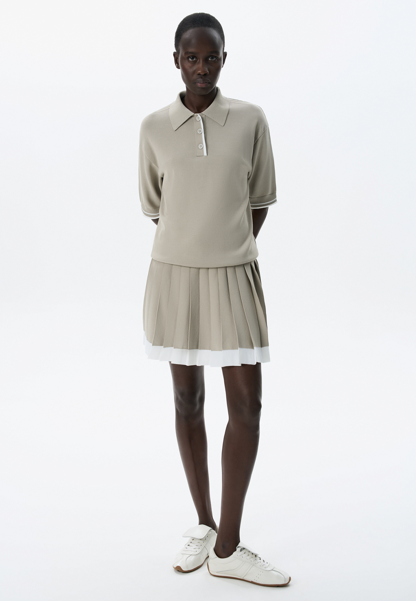 Трикотажная футболка поло из вискозы. Модель прямого силуэта, со спущенной линией плеч, короткими рукавами, отложным воротником-поло и планкой с тремя пуговицами. Рукава и нижний край изделия декорированы кантом контрастного цвета.