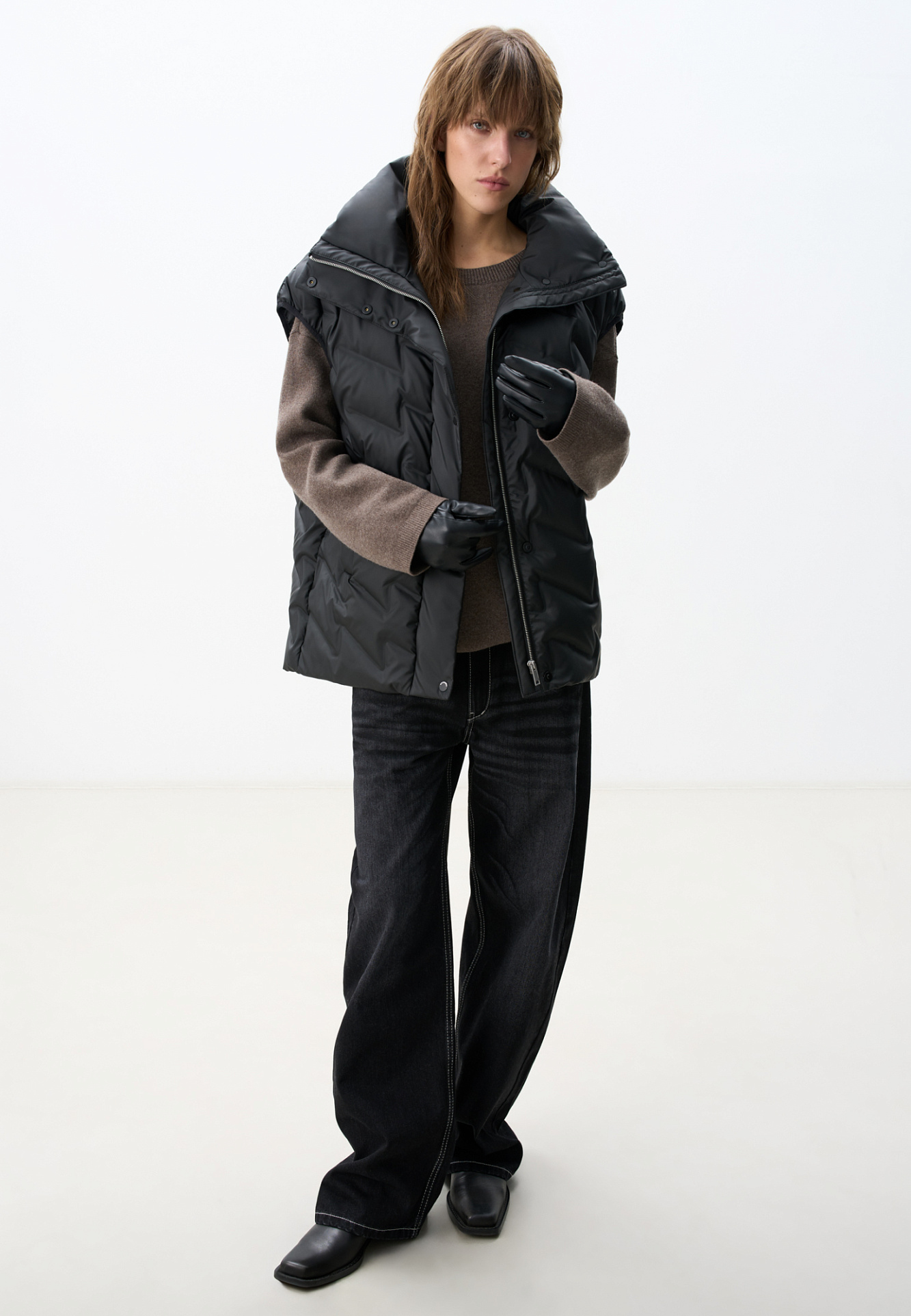 Объемный стеганый жилет на пуху. Модель прямого кроя, с воротником стойкой и боковыми карманами. Застежка на молнию и кнопки под планкой.