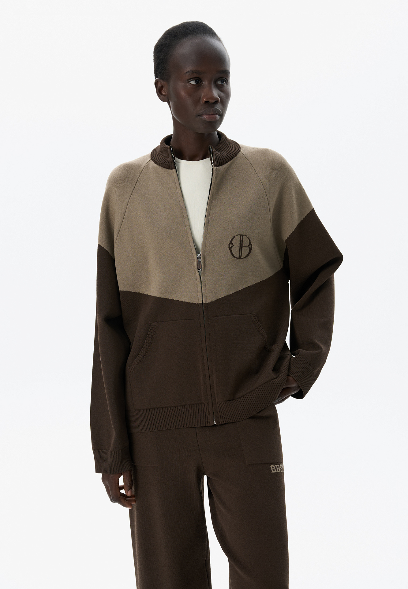 Трикотажный бомбер из вискозы с добавлением эластана. Модель прямого силуэта, с рукавом реглан, невысоким воротником-стойкой и боковыми карманами. Изделие декорировано брендированным жаккардом на груди. Застежка на молнию.