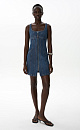 Джинсовое платье длины мини из хлопка. Модель приталенного силуэта на широких бретельках, с двумя боковыми карманами, карманами сзади и застежкой на молнию. Платье имеет отрезной лиф с декоративными швами.