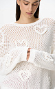 Трикотажный ажурный джемпер из хлопка. Модель свободного силуэта, со спущенной линией плеч, длинными рукавами и круглым вырезом горловины. Изделие декорировано объемными деталями в виде сердечек.