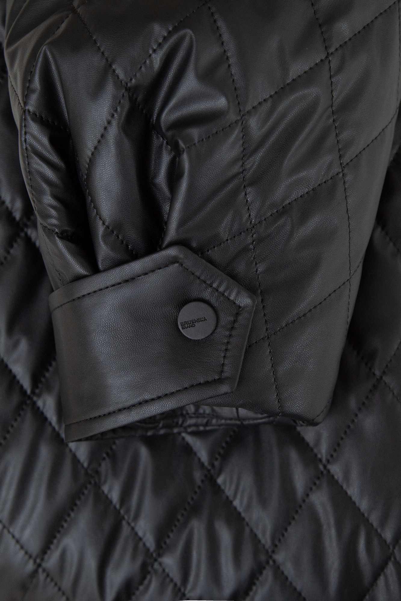 Укороченный стеганый бомбер из экокожи с воротником стойкой. Длинные рукава с манжетами на кнопках. Передние боковые карманы. Эластичный широкий пояс на резинке. Застегивается на металлическую молнию.