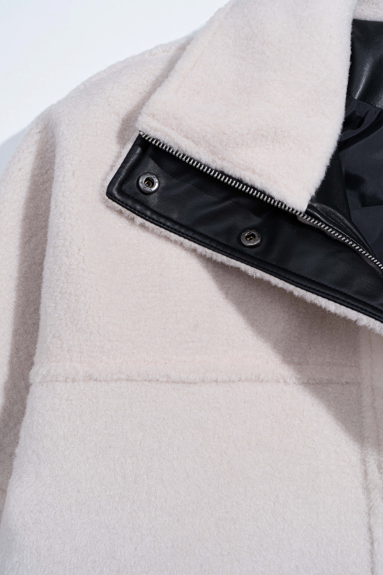 Шуба из экомеха с воротником-стойкой. Модель свободного силуэта с боковыми карманами. Застежка на молнию под планкой с кнопками.